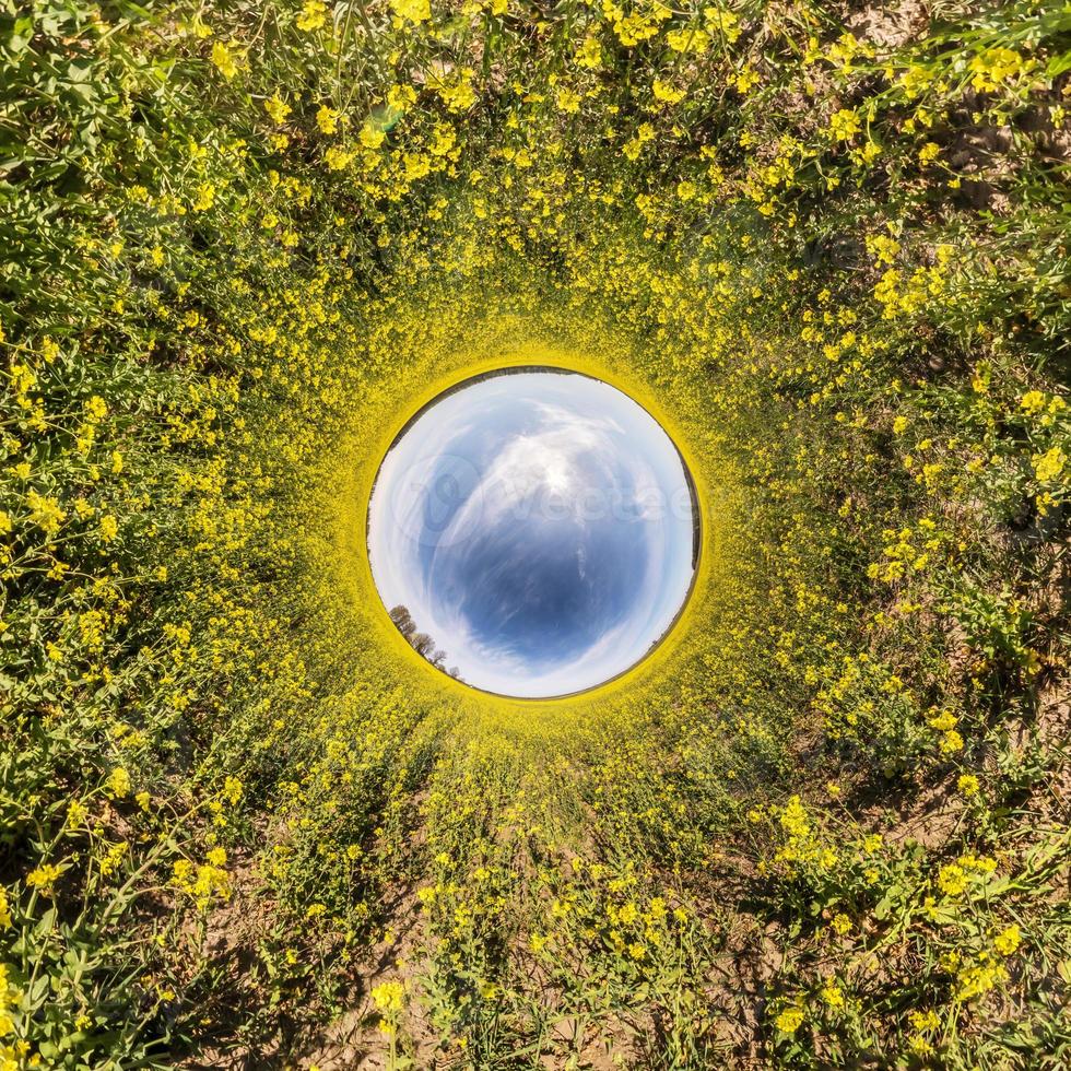 inversie van kleine planeet transformatie van bolvormig panorama 360 graden. sferische abstracte luchtfoto in koolzaadveld met geweldige mooie wolken. kromming van de ruimte. foto