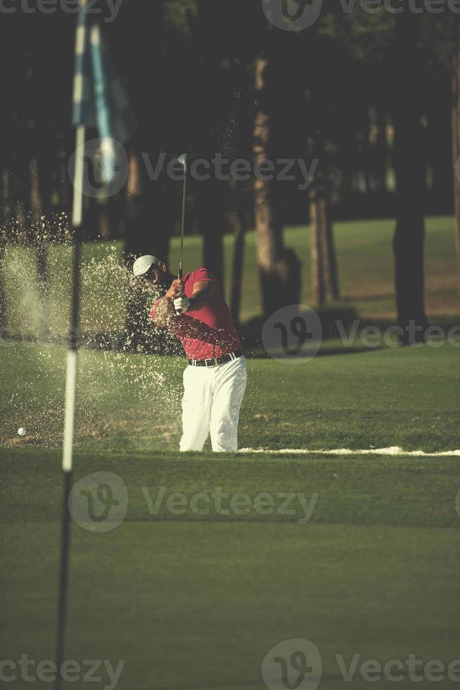 golfspeler raken een zand bunker schot foto