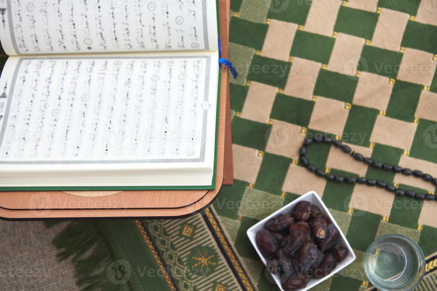 iftar tijd droog datums heilig koran glas van water en tasbih Aan bidden tapijt of sejadah foto