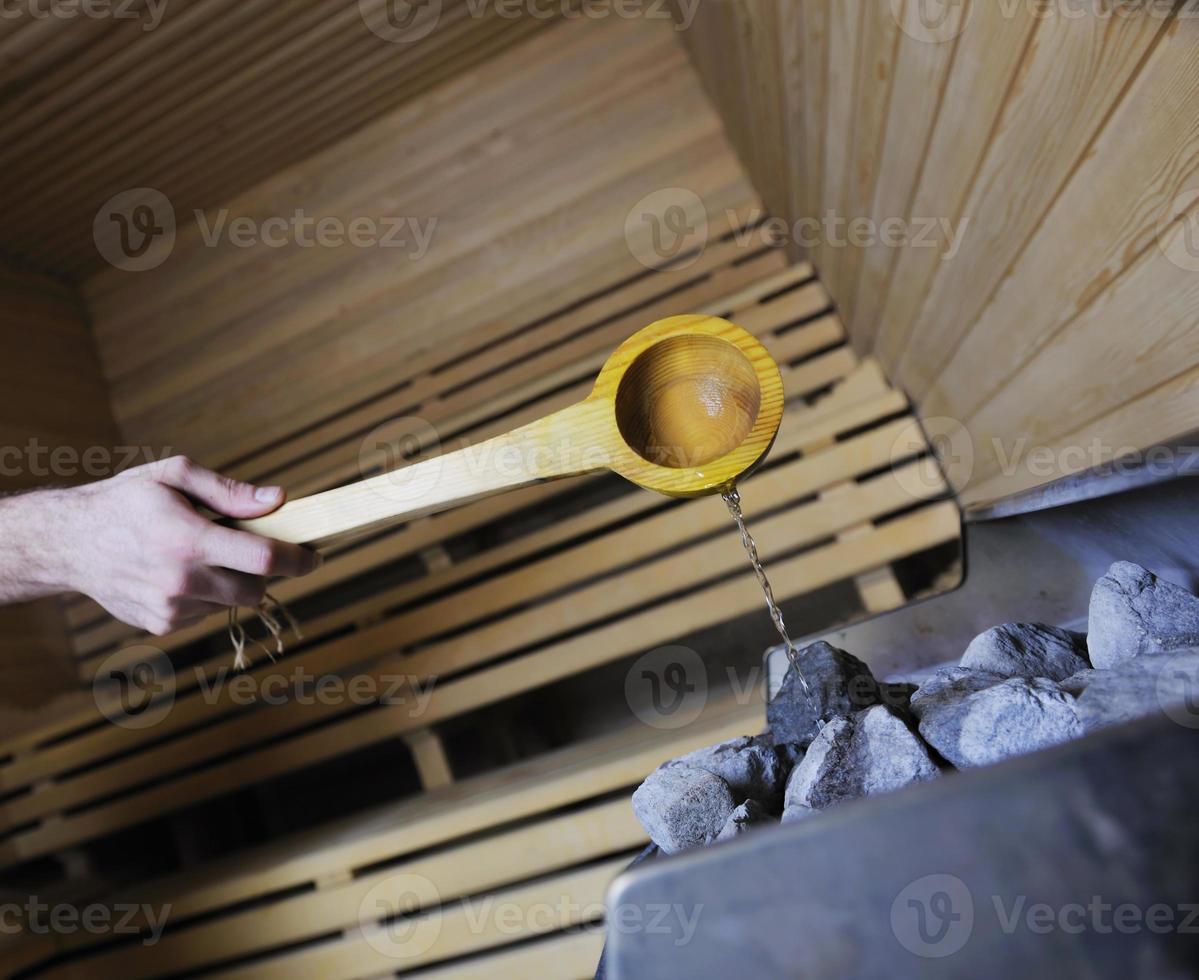 heet stenen en spatten water in sauna foto
