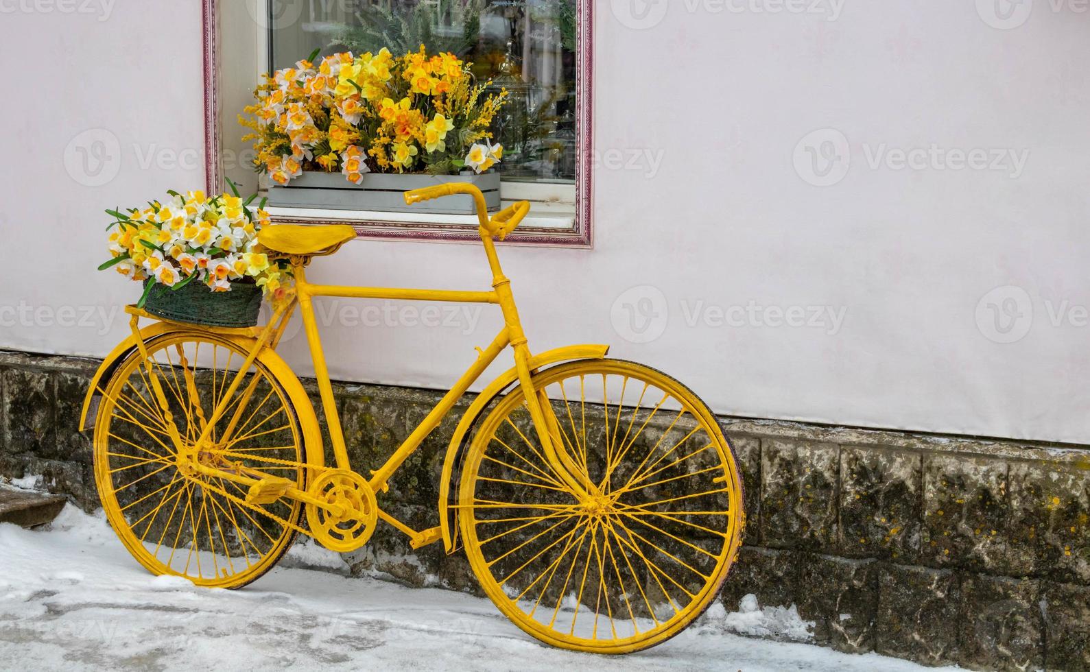 geel fiets staat Aan de achtergrond van de muur, onder de venster van de bloem winkel, wijnoogst stijl foto