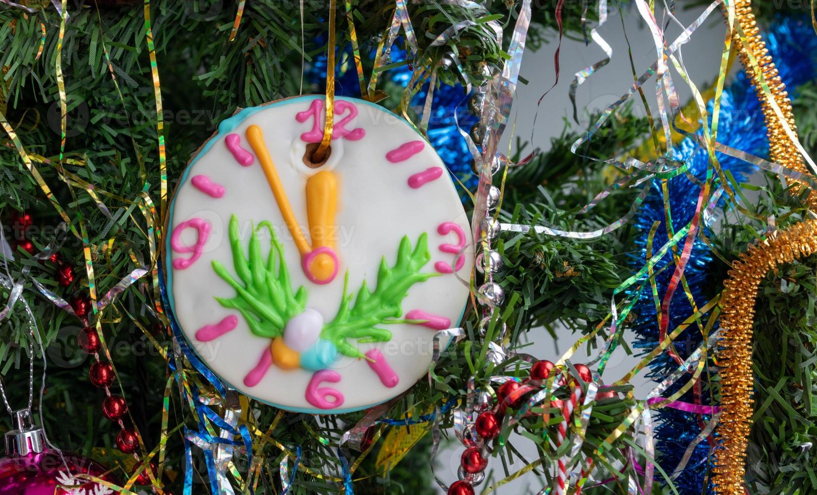 detailopname van een Kerstmis boom met ornamenten van kerstballen, sneeuwvlokken, klatergoud, slingers en een groot peperkoek-klok foto