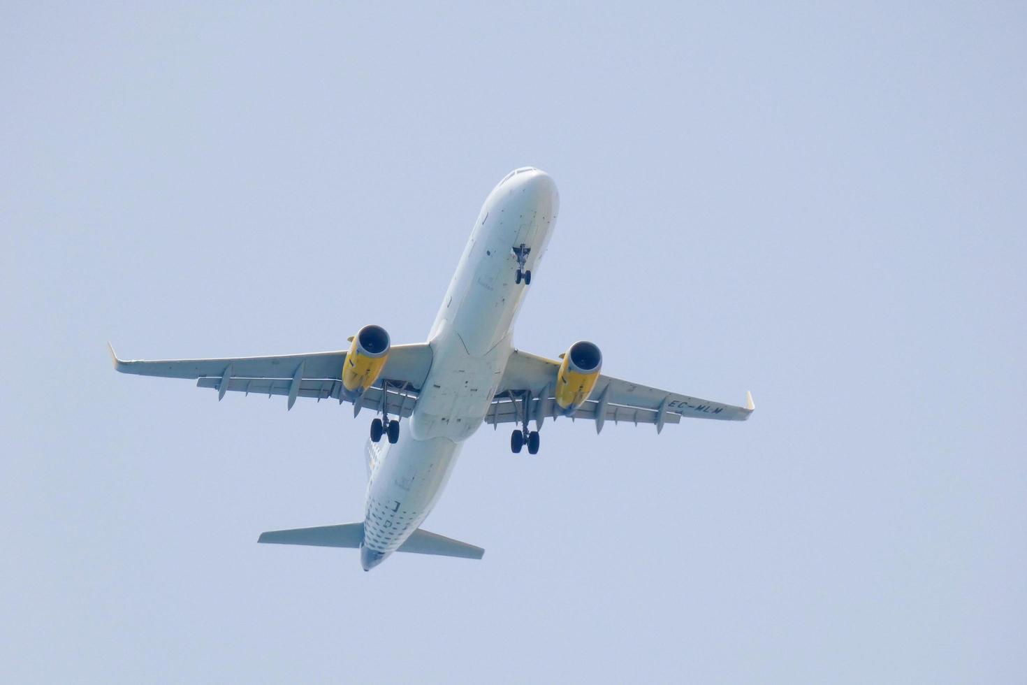 reclame vliegtuig vliegend onder blauw luchten en aankomen Bij de luchthaven foto