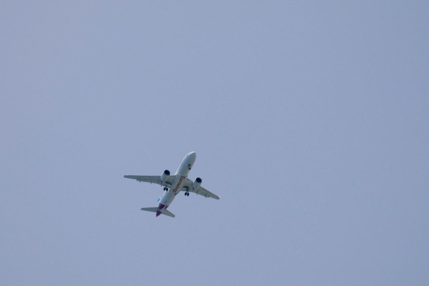 reclame vliegtuig vliegend onder blauw luchten en aankomen Bij de luchthaven foto