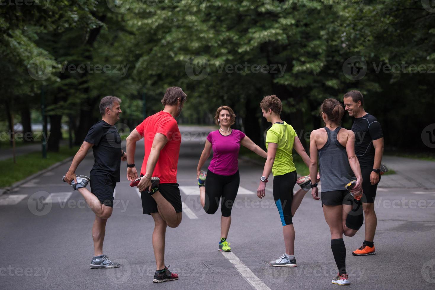 hardlopers team opwarming omhoog en uitrekken voordat ochtend- opleiding foto