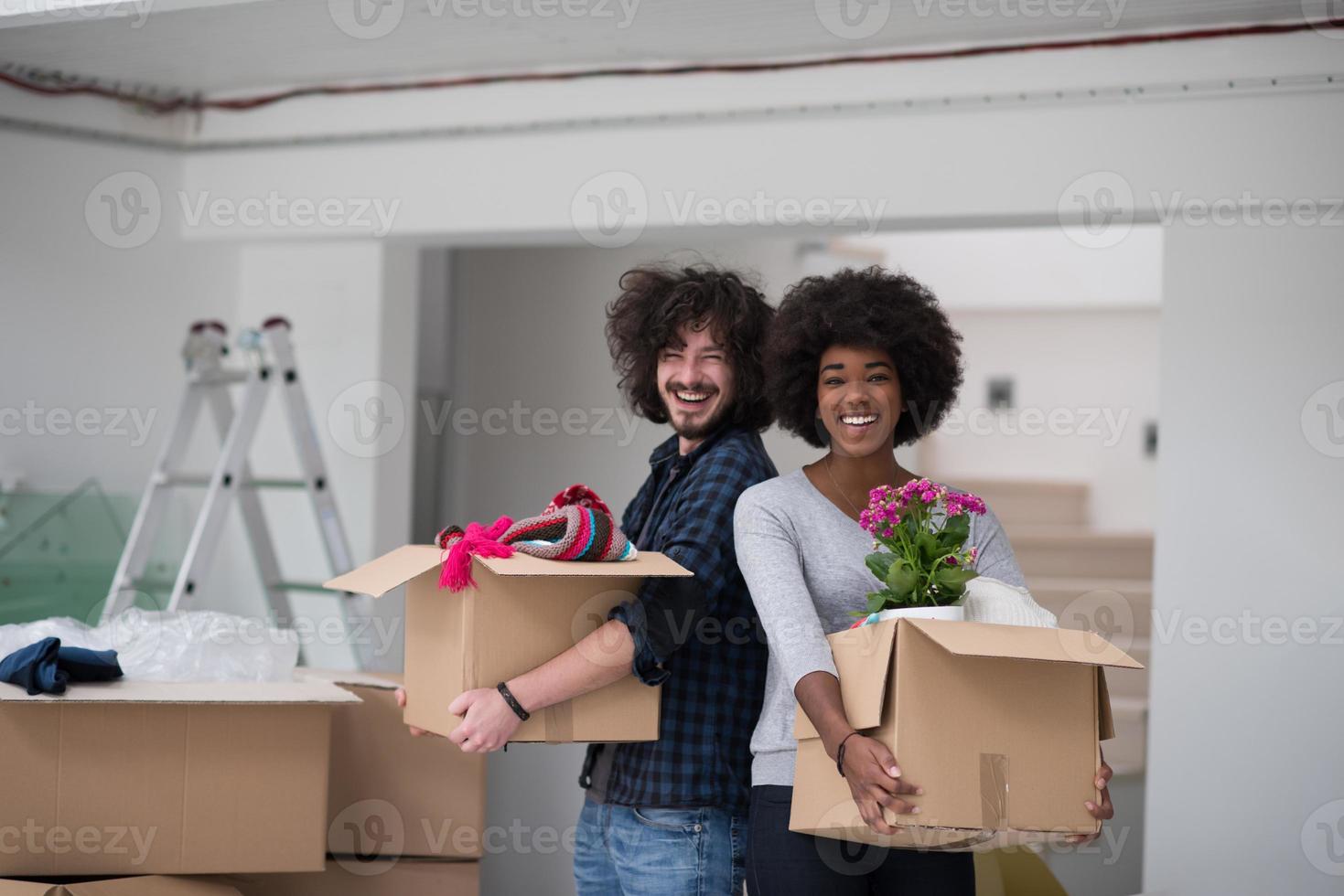 multi-etnisch paar in beweging in een nieuw huis foto
