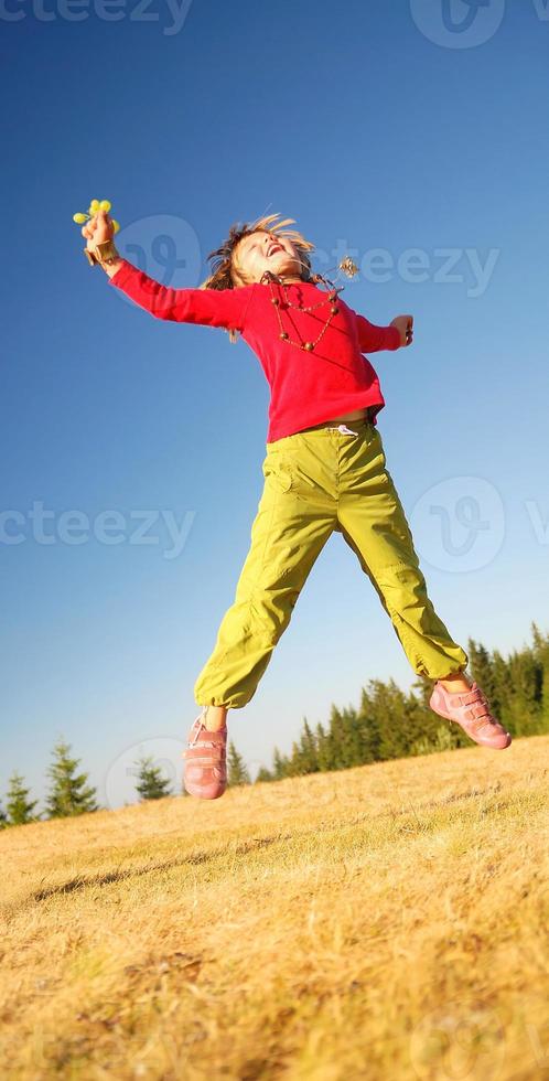 kind jumping in veld- foto
