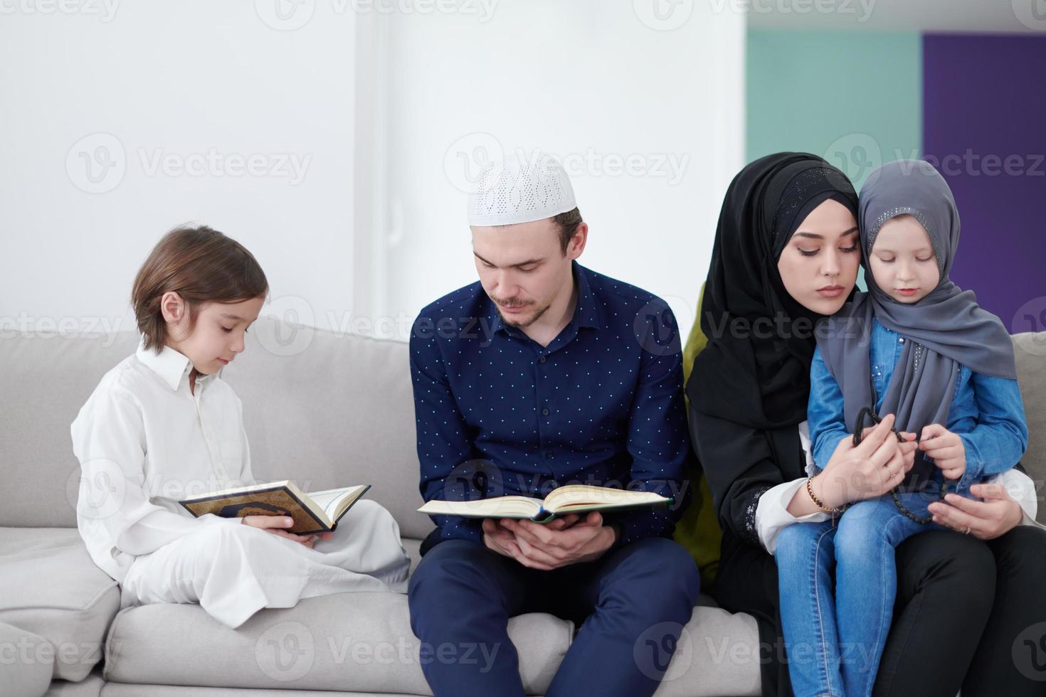 moslim familie lezing koran en bidden Bij huis foto