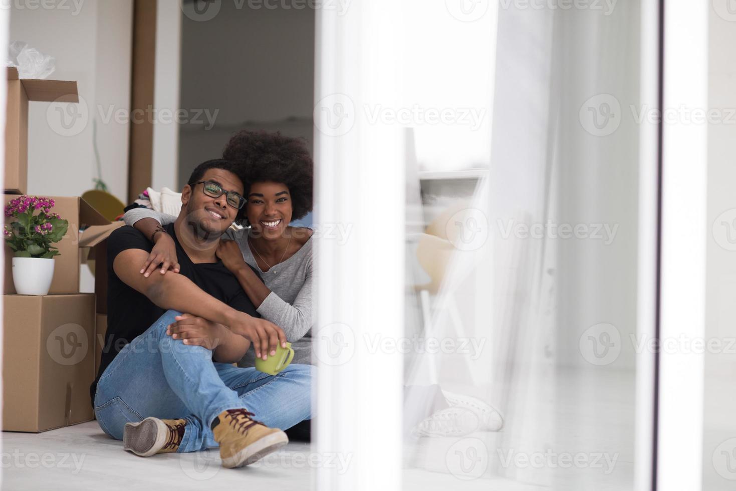 Afrikaanse Amerikaans paar ontspannende in nieuw huis foto