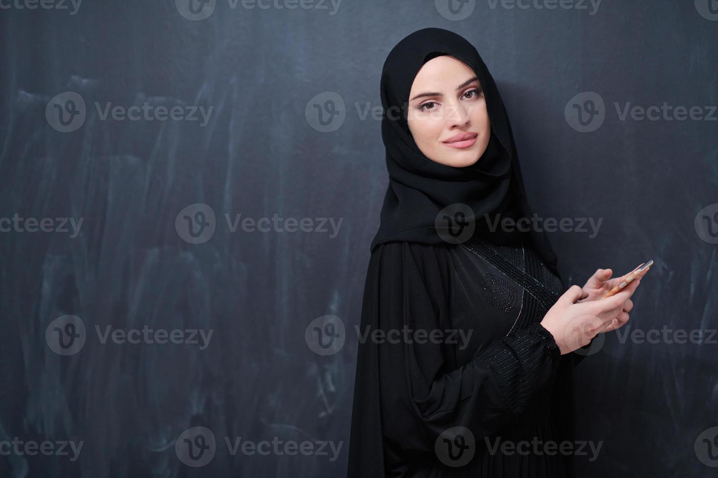 jong modern moslim bedrijf vrouw gebruik makend van smartphone foto