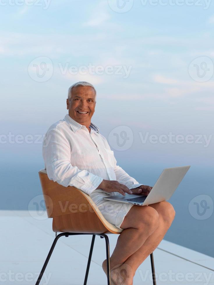 ontspannen senior Mens Aan balkon foto