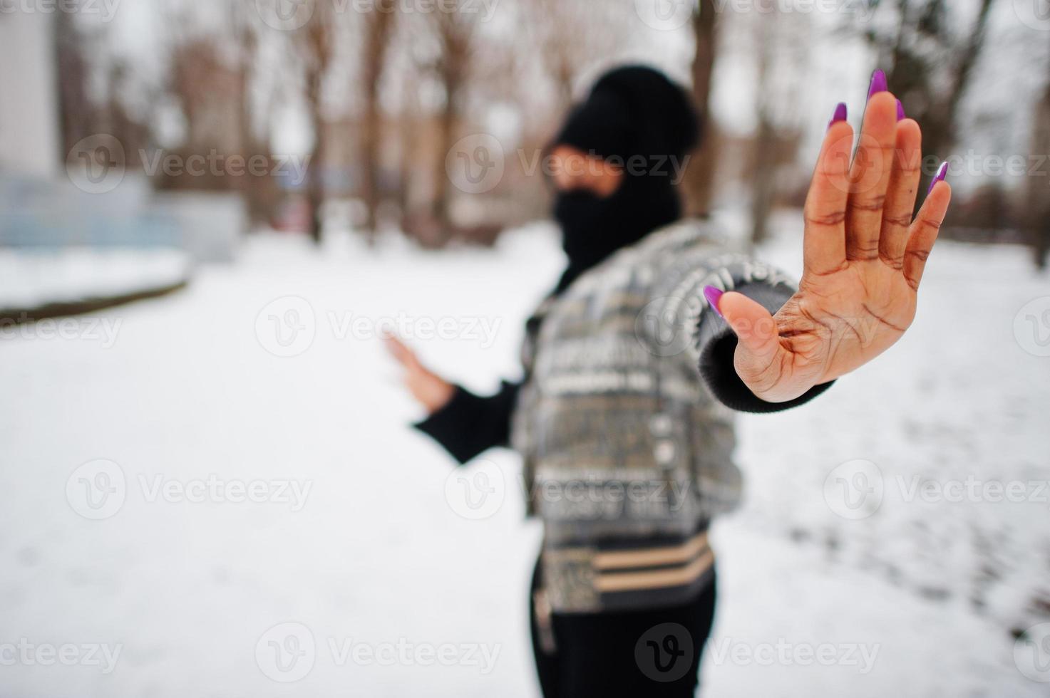 Afrikaanse moslim vrouw slijtage in zwart hijab sjaal houding in winter dag Bij Europa en tonen hou op teken door hand. foto