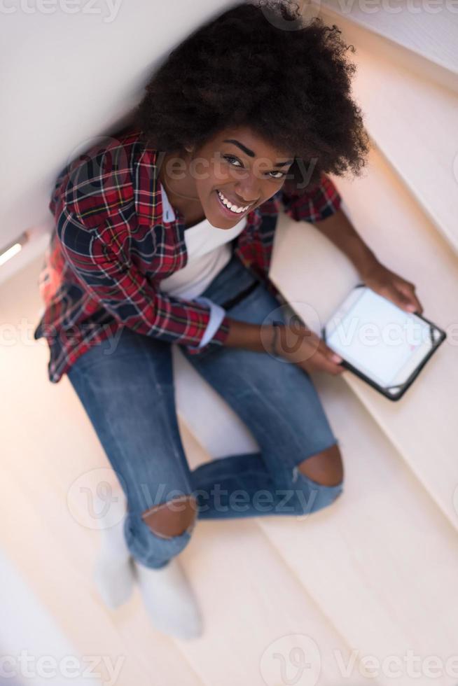zwart vrouw gebruik makend van haar elektronisch tablet foto