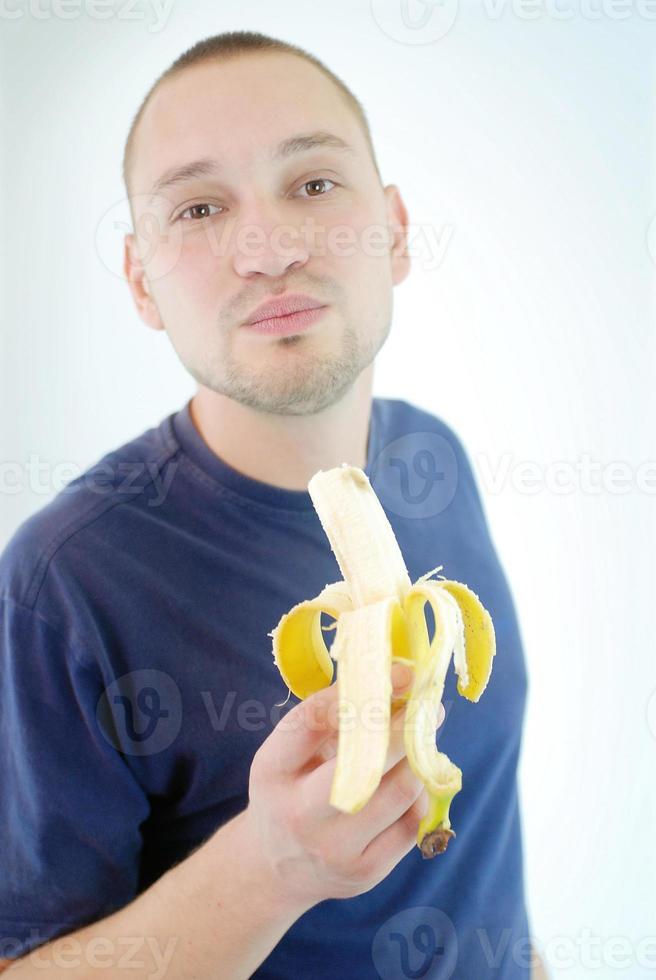 Mens aan het eten banaan foto