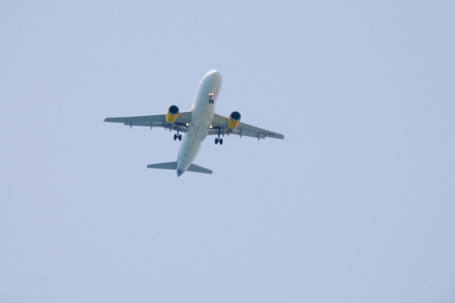 reclame vliegtuig vliegend onder blauw luchten en aankomen Bij de luchthaven foto