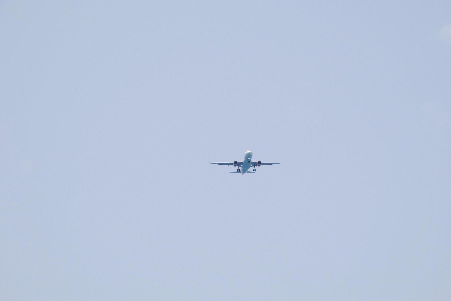 reclame vliegtuig vliegend onder blauw luchten en aankomen Bij de luchthaven foto