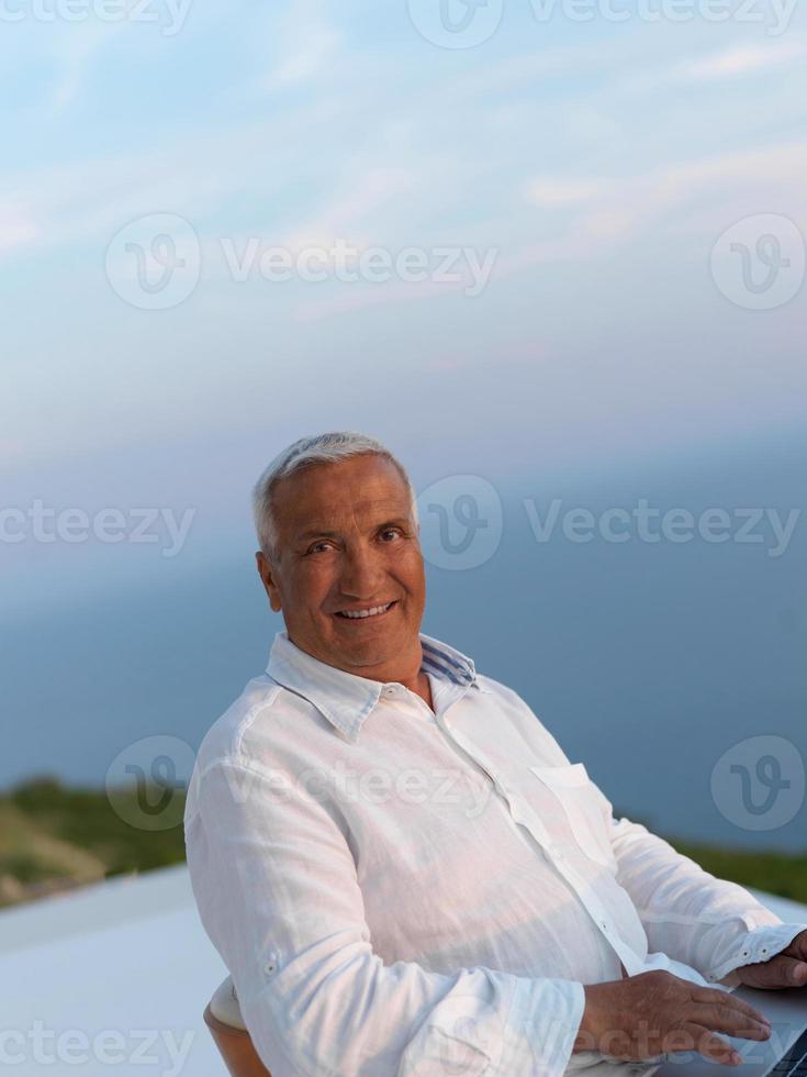 ontspannen senior Mens Aan balkon foto