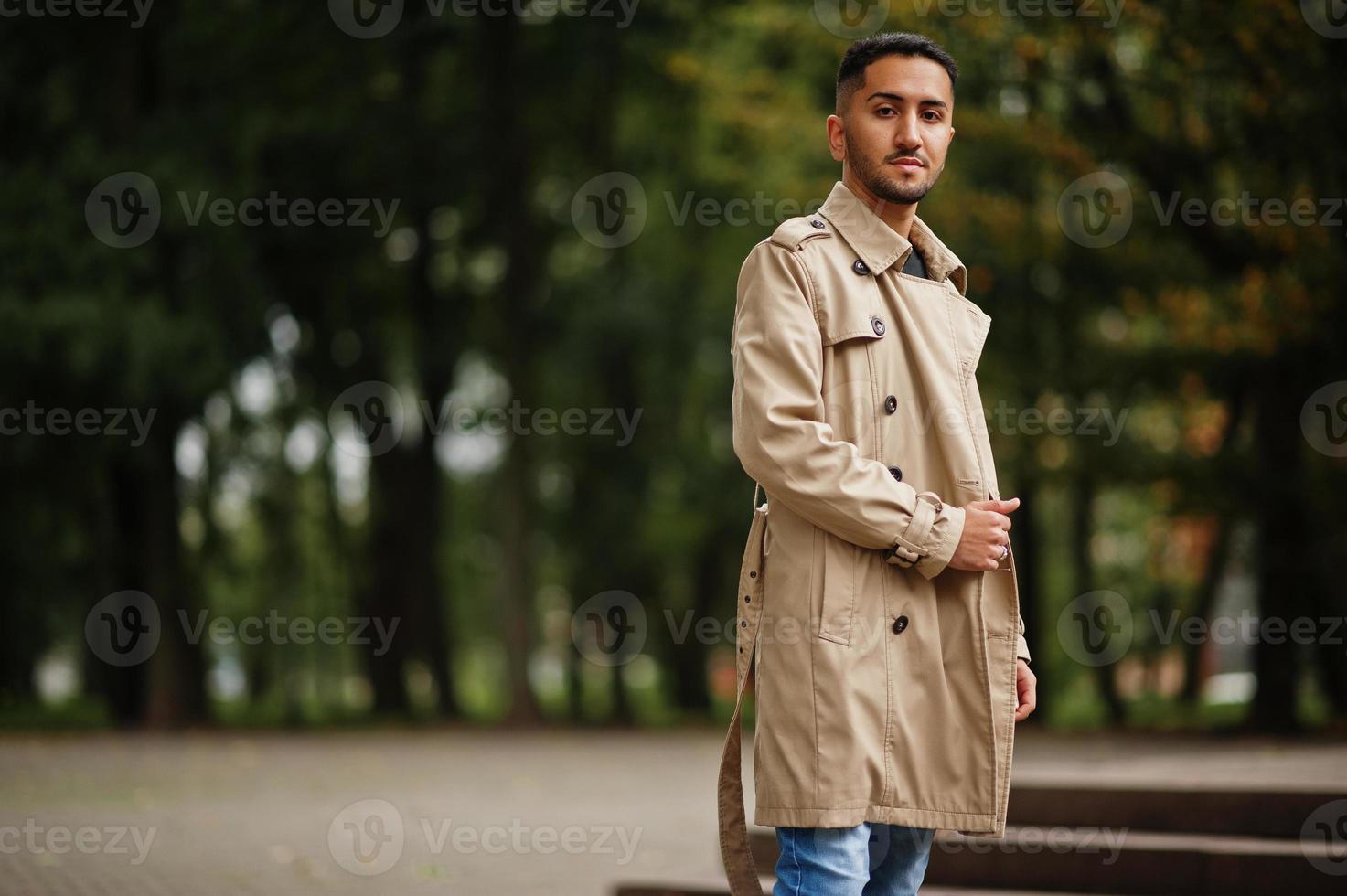 elegant Koeweit Mens Bij loopgraaf jas wandelen Bij park. foto