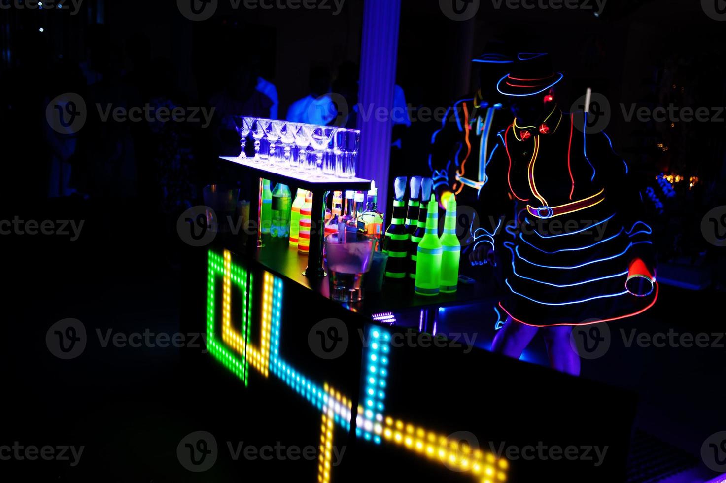 professioneel barman en LED licht show. silhouet van modern barman beven drinken Bij nacht cocktail bar. foto