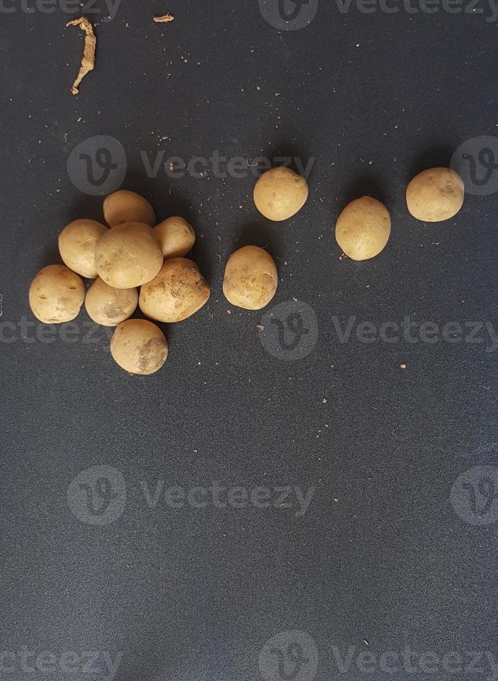 klein aardappelen Aan een zwart tafel. foto
