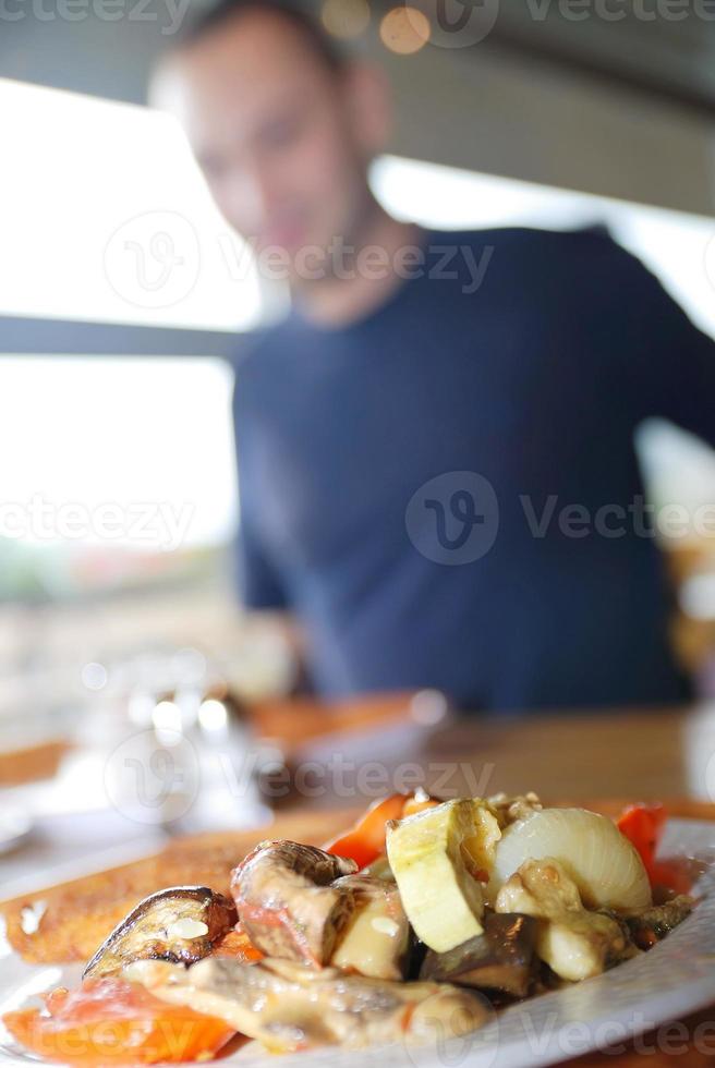 Mens aan het eten gezond voedsel het een restaurant foto