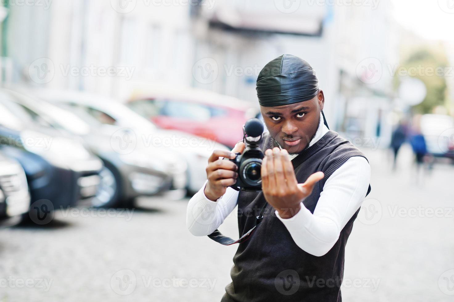 jong professioneel Afrikaanse Amerikaans videograaf Holding professioneel camera met pro apparatuur. afro cameraman vervelend zwart Duraq maken een videos. foto