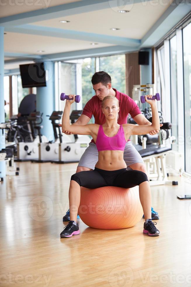 jong sportief vrouw met trainer oefening gewichten hijs- foto