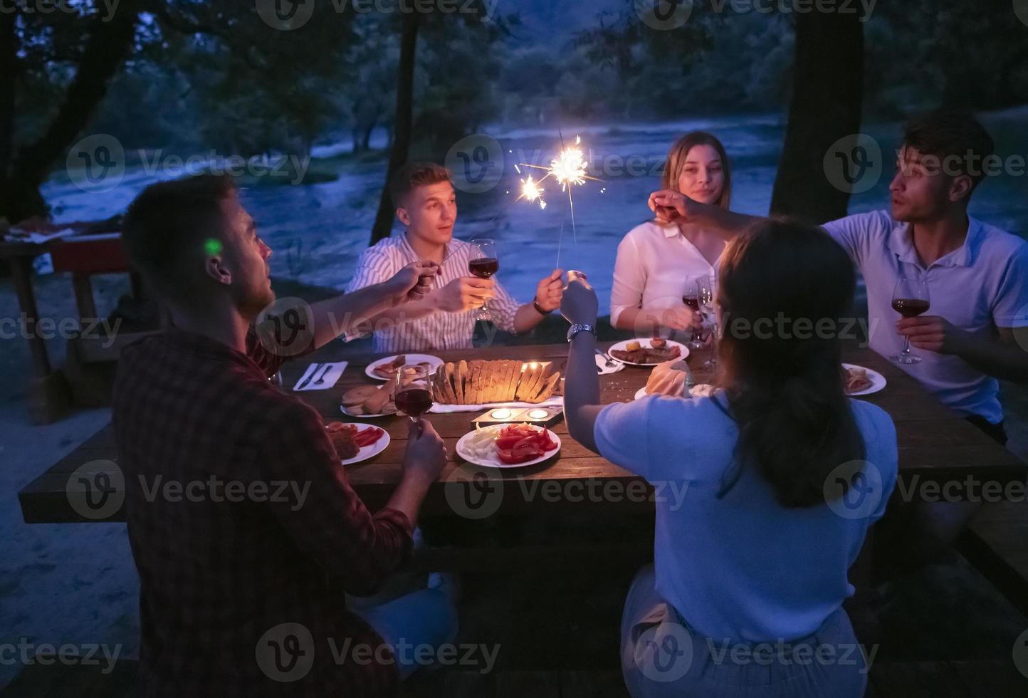 vrienden hebben picknick Frans avondeten partij buitenshuis gedurende zomer vakantie foto