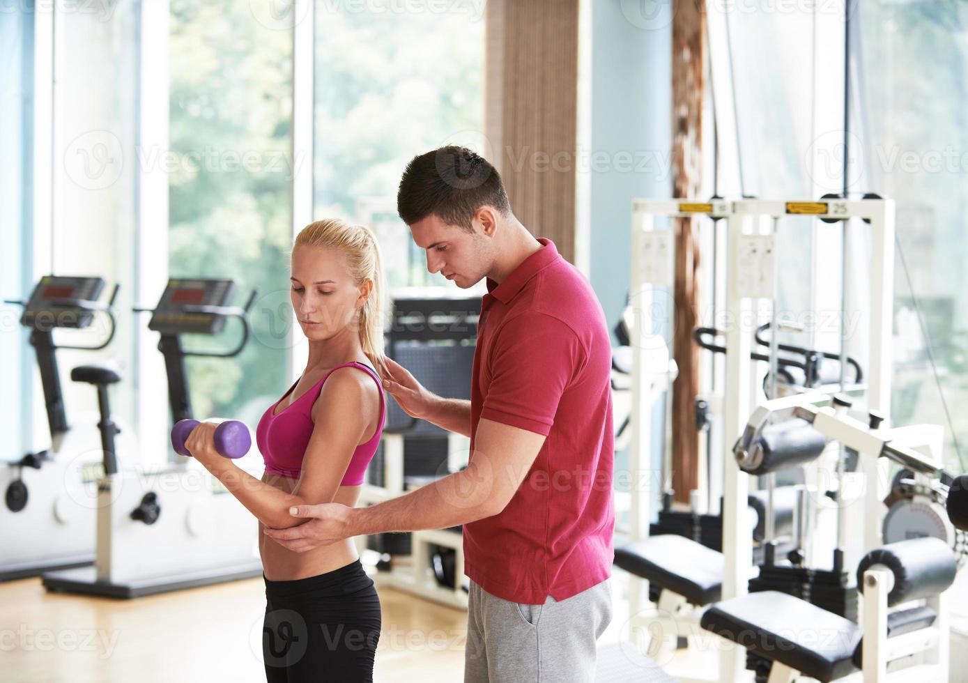 jong sportief vrouw met trainer oefening gewichten hijs- foto