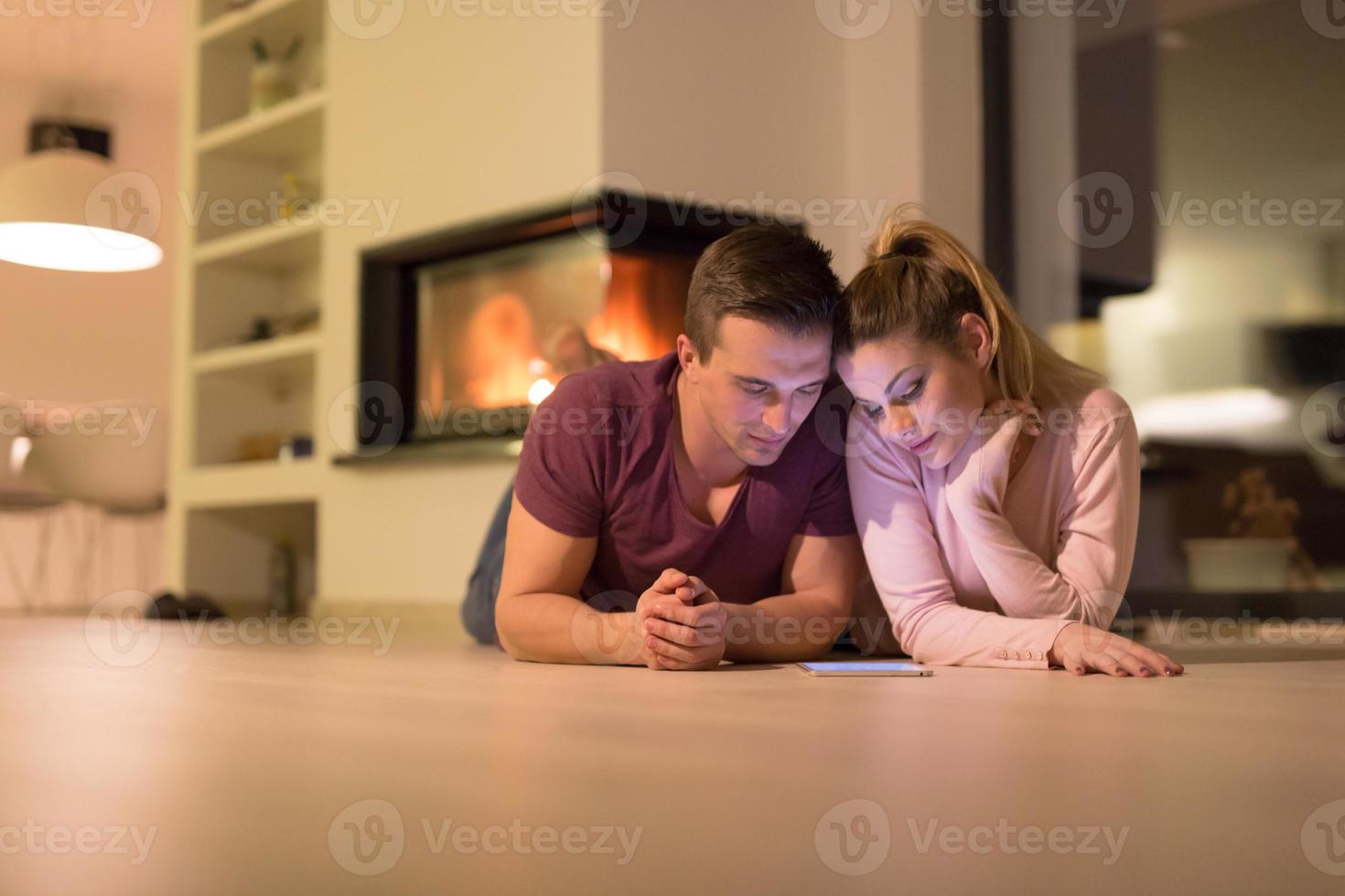 jong paar gebruik makend van digitaal tablet Aan verkoudheid winter nacht foto