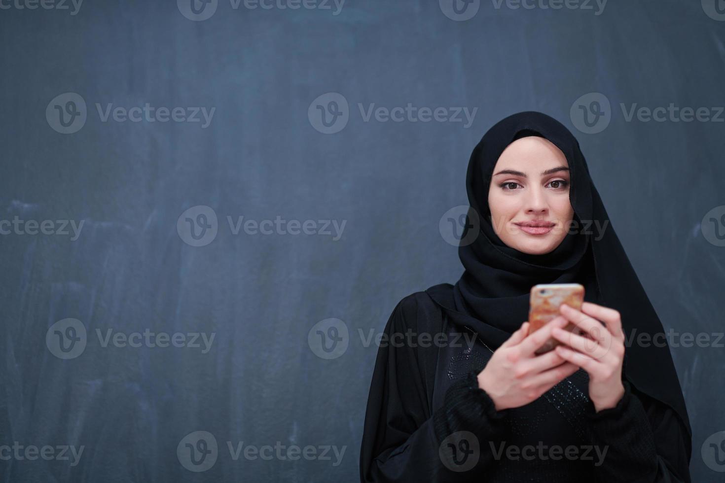 jong modern moslim bedrijf vrouw gebruik makend van smartphone foto
