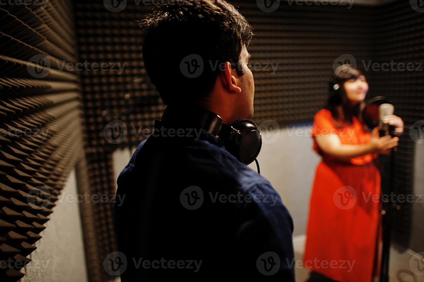 jong Aziatisch duet zangers met microfoon opname lied in Vermelding muziek- studio. foto