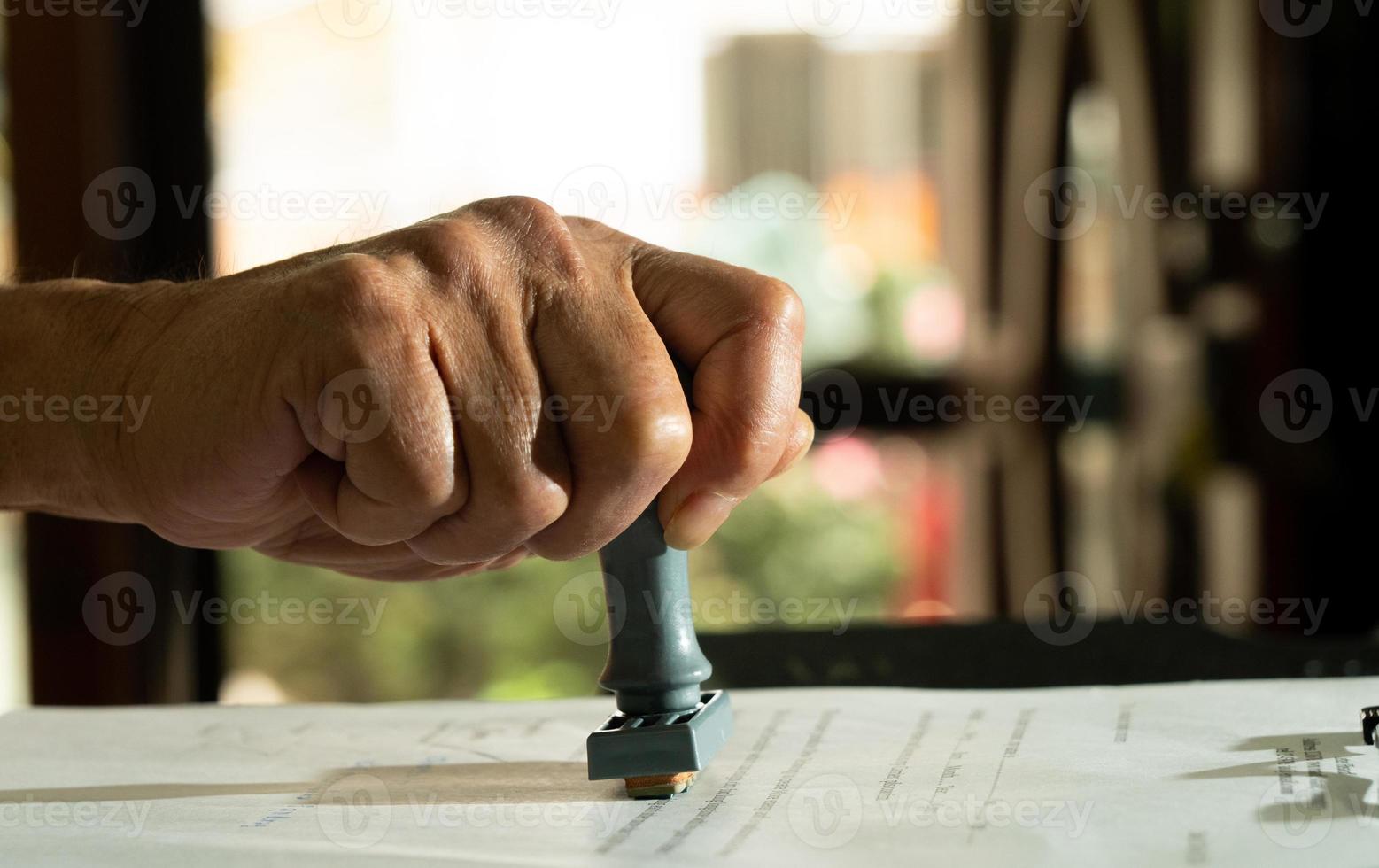 persoon ondertekening goedkeuring document, certificaat, wettelijk overeenkomst in kantoor door pen en postzegel hand. Gezag van toepassing zijn wet naar Doen contract papierwerk het formulier door openbaar notaris klerk of officieel advocaat, kopiëren ruimte foto