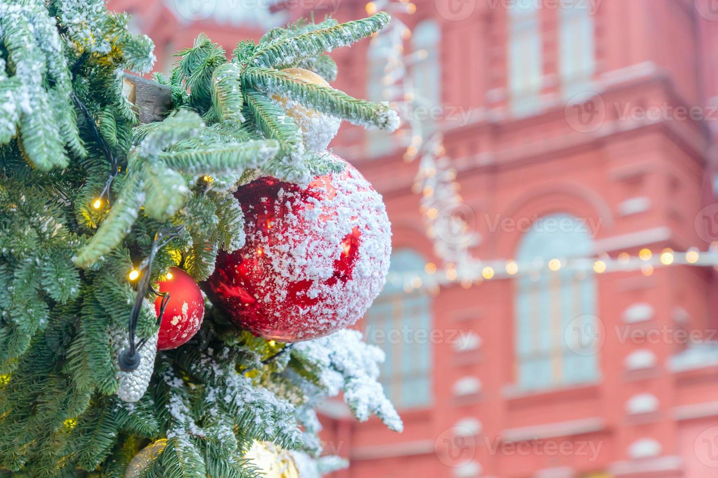 dichtbij omhoog van Kerstmis boom decoratie met kerstballen en sneeuw glazuur. feestelijk groet kaart voor winter vakantie in gouden kleuren. foto
