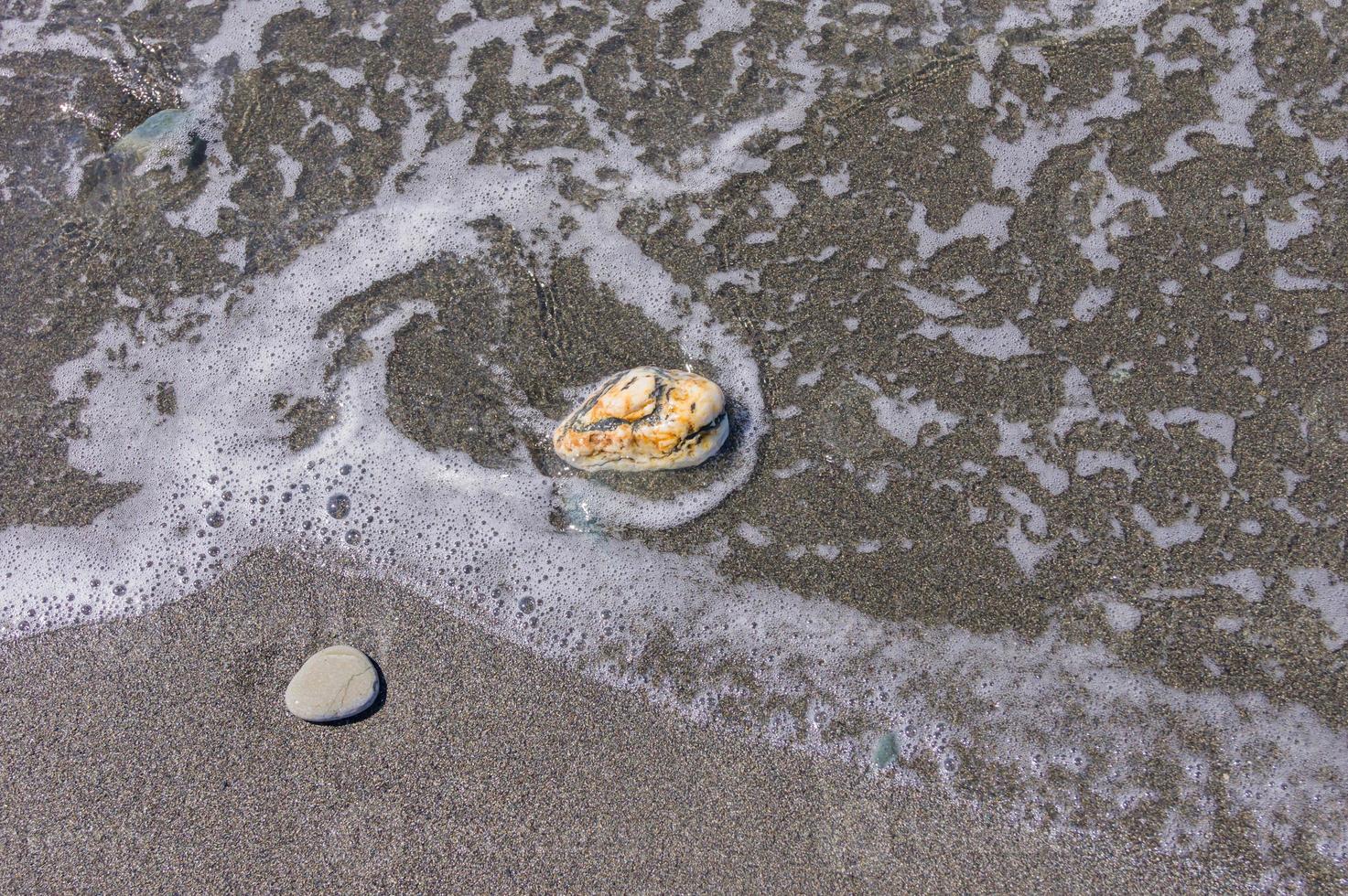 kiezelstrand. kust met transparant water en kleine steentjes foto