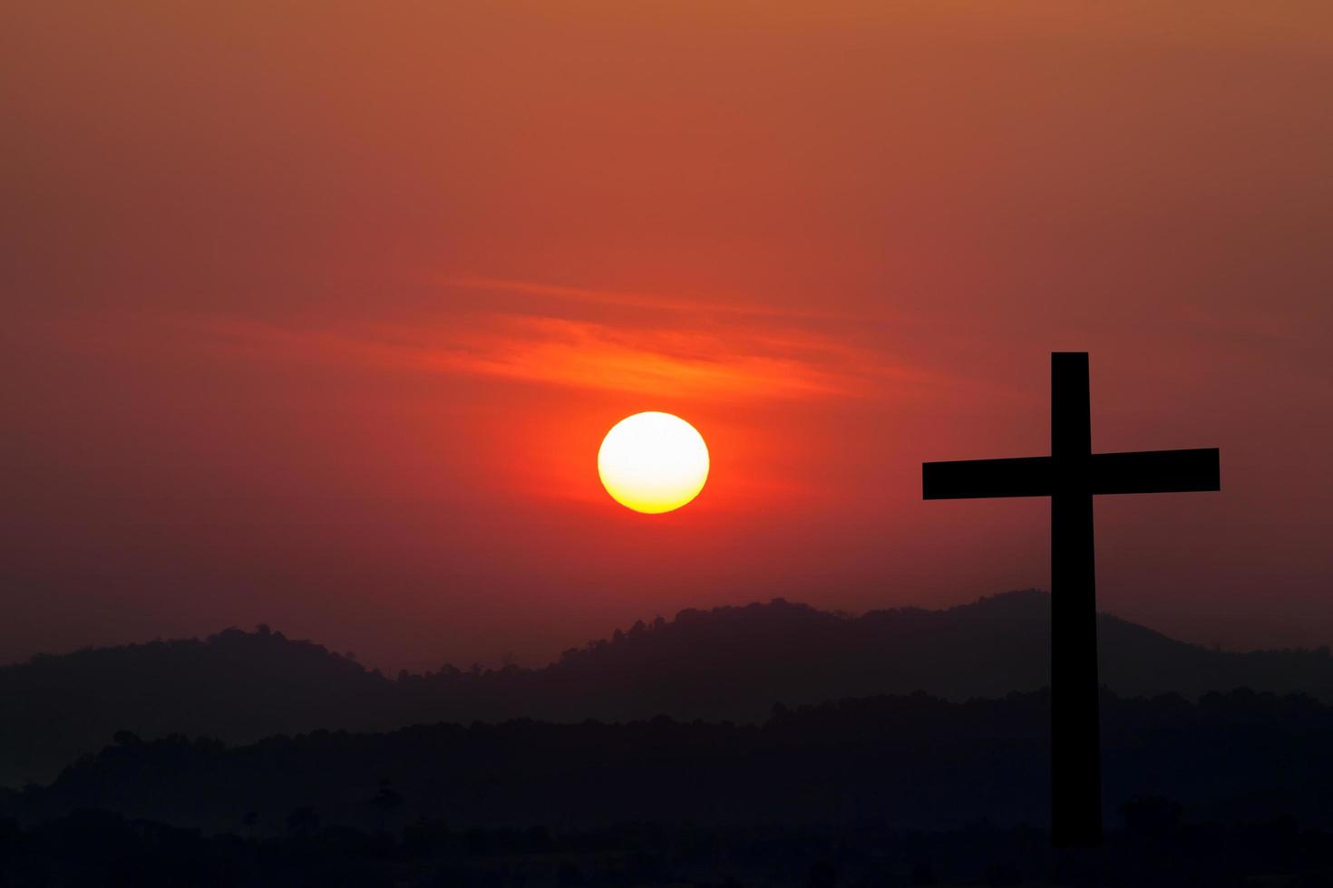 silhouet van kruis over- zonsondergang achtergrond foto