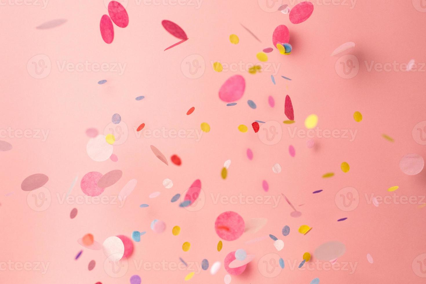 kleurrijk confetti Aan pastel roze achtergrond. helder en feestelijk vakantie achtergrond. foto