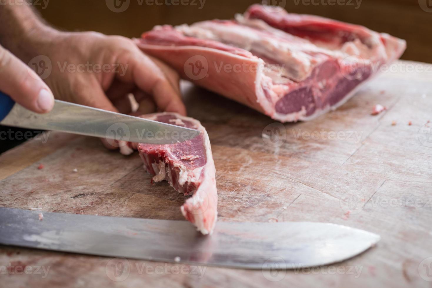 close up van slager snijden rauw vlees met scherp mes foto