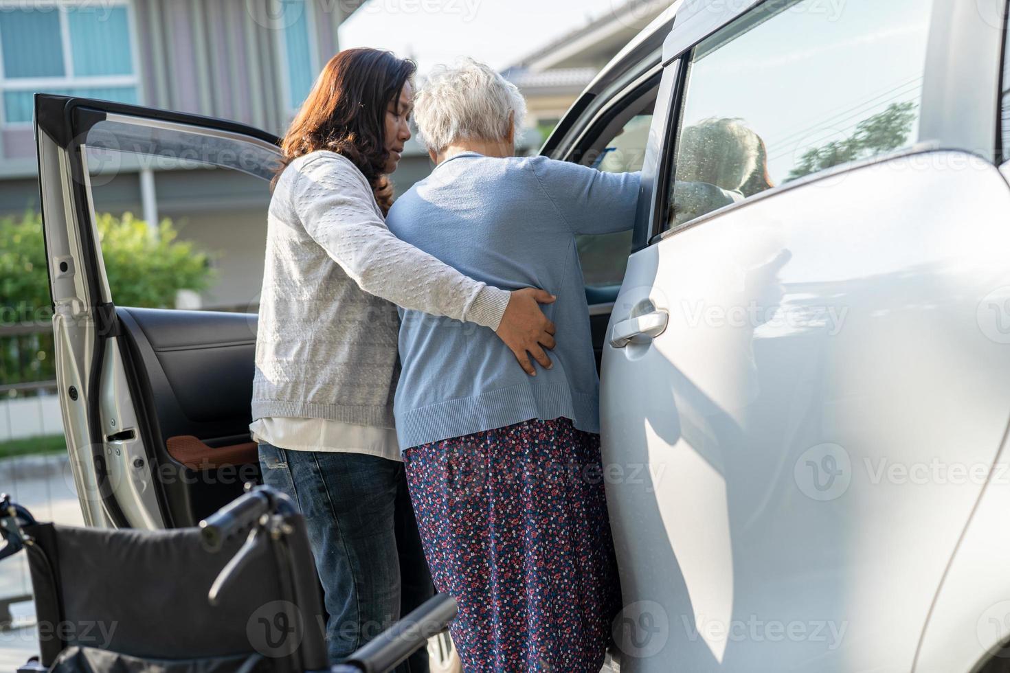 verzorger helpen Aziatisch senior of ouderen oud dame vrouw geduldig krijgen naar haar auto, gezond sterk medisch concept. foto