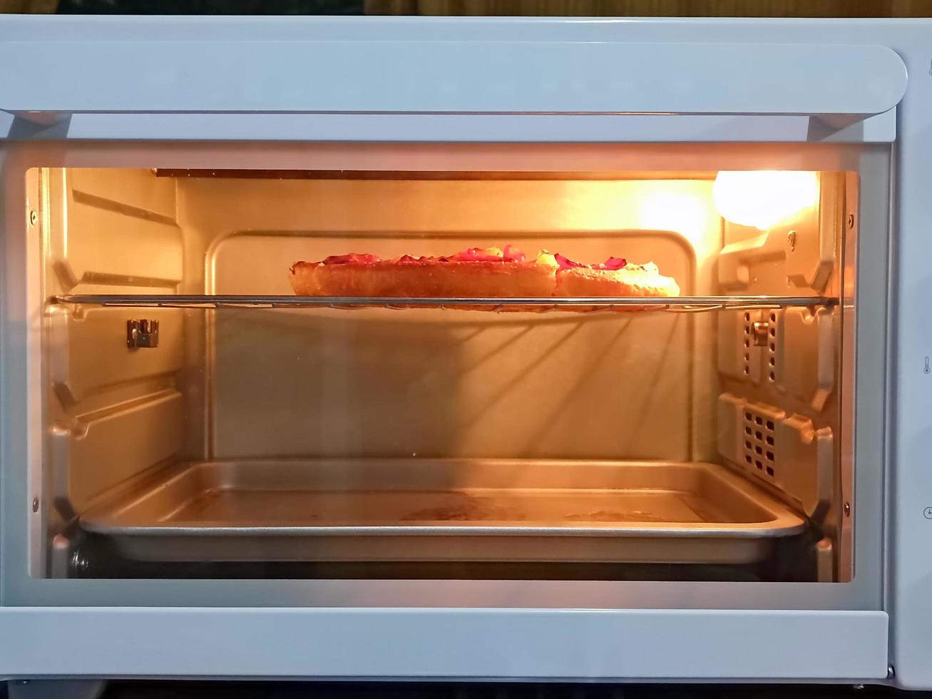 opwarmen de pizza in een oven Bij huis foto