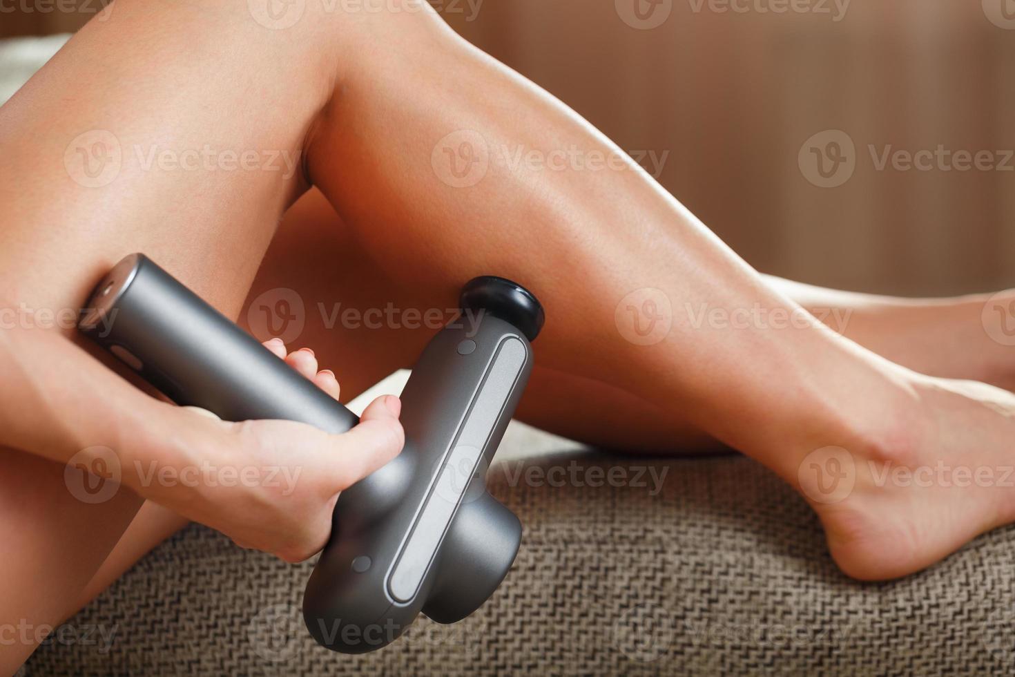 massage van vrouwen poten met een schok massage apparaat. foto