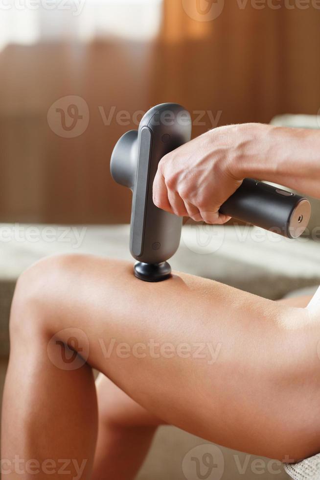 massage van vrouwen poten met een schok massage apparaat. foto