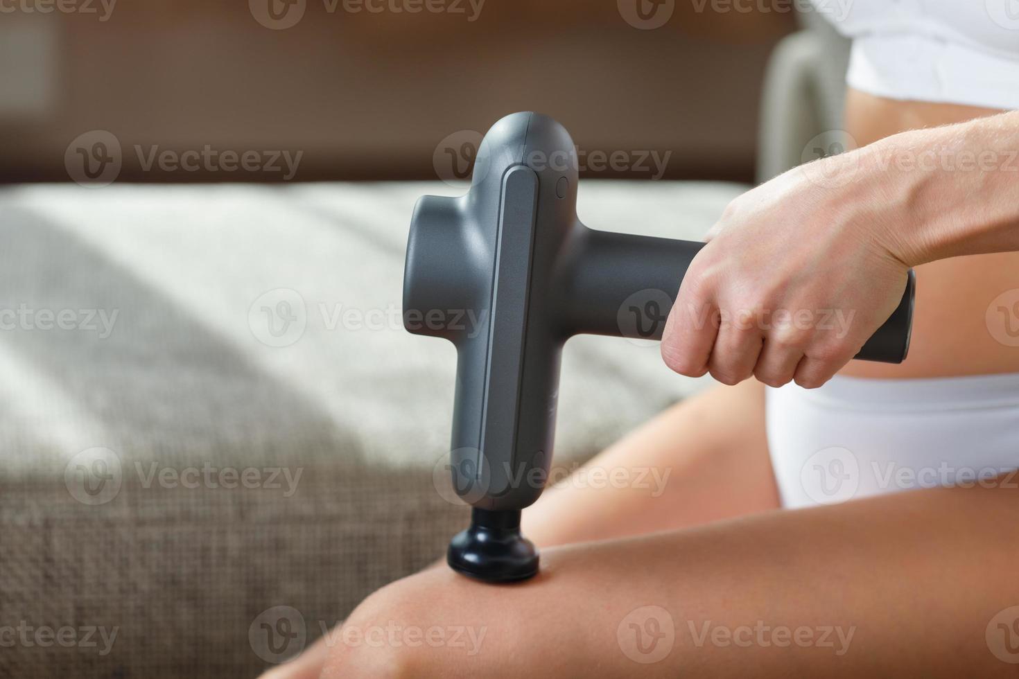 massage van vrouwen poten met een schok massage apparaat. foto