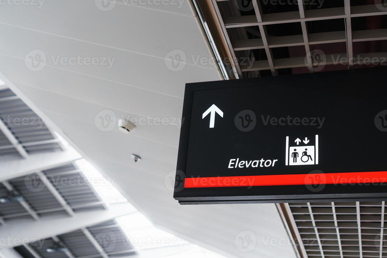 een teken met een pijl richten naar de lift in de luchthaven aan het wachten terminal. foto