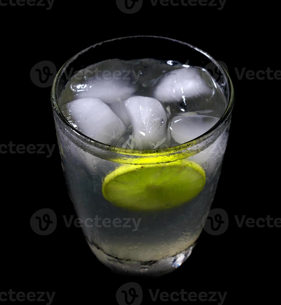 limonade met ijs in kristal glas Aan zwart achtergrond foto