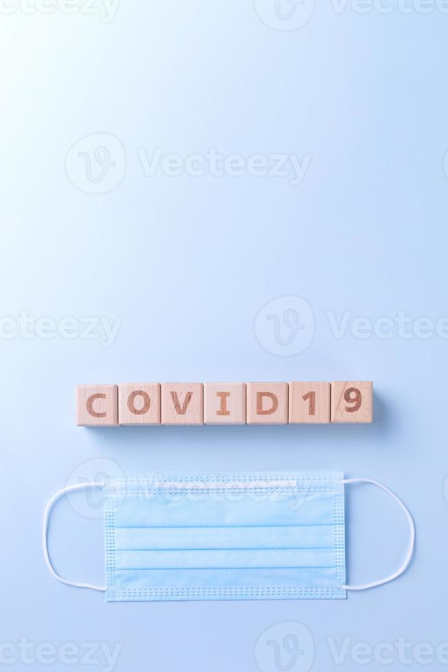 covid-19 woord houten kubus met masker, medisch apparatuur, wereld ziekte pandemisch infectie en het voorkomen concept, top visie, vlak leggen, overhead ontwerp foto