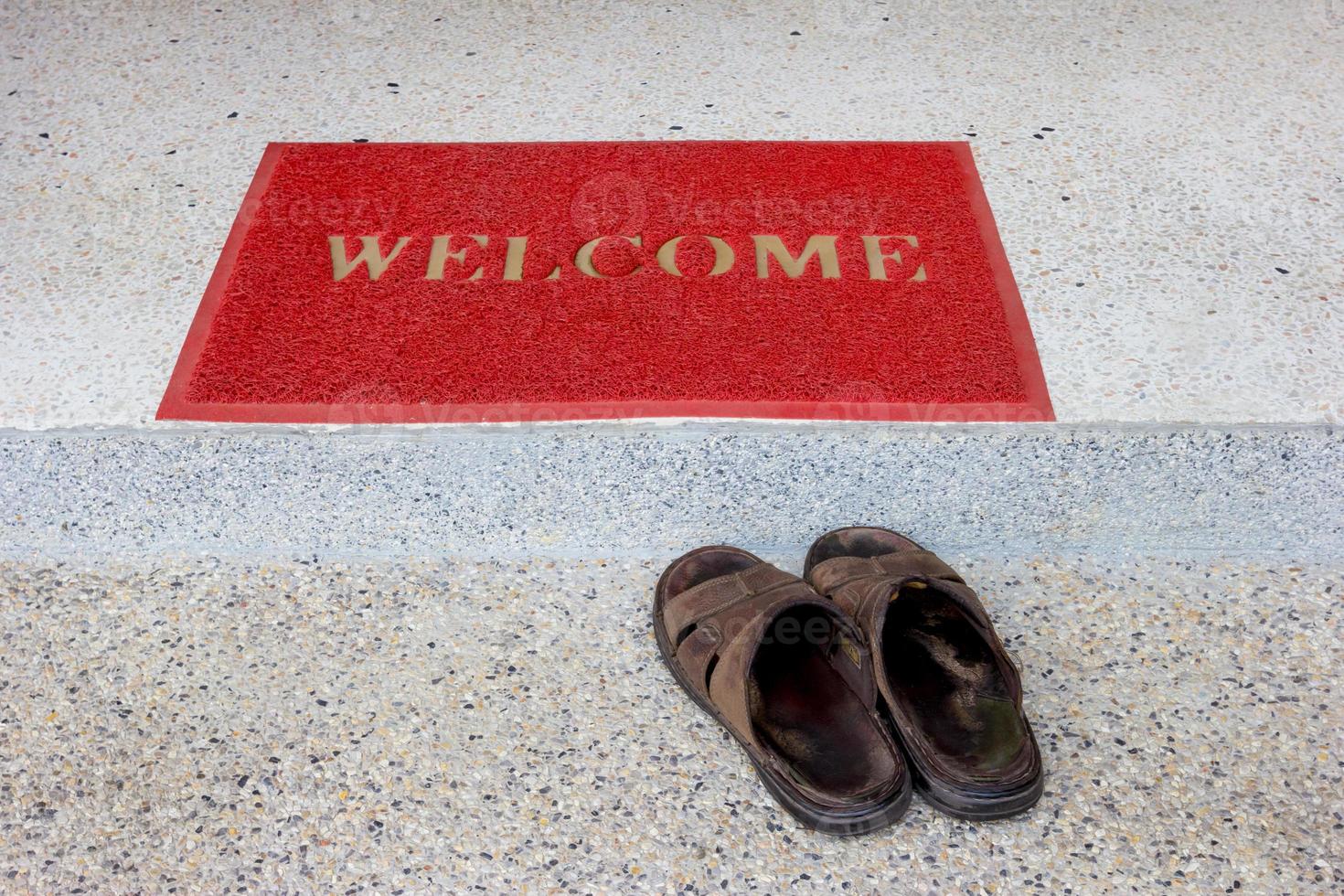 rood Welkom deurmat Aan trappenhuis en oud sandalen foto