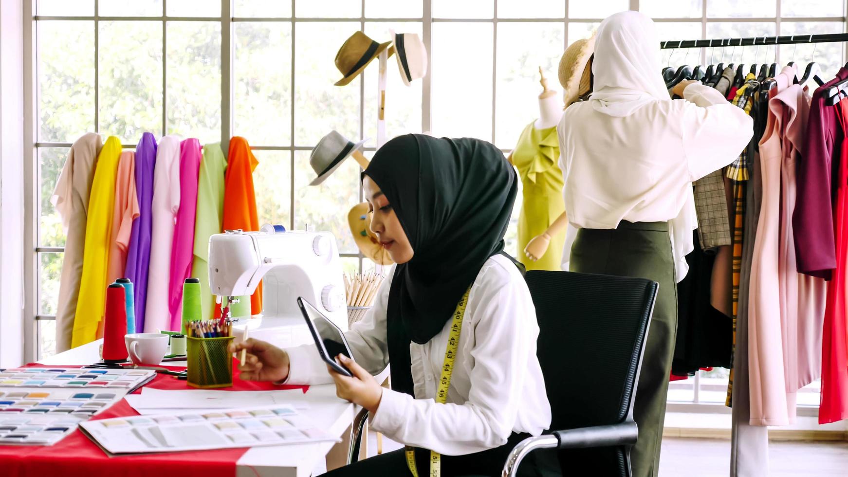 mooi moslim Dames werken samen Bij de kleding kantoor. foto