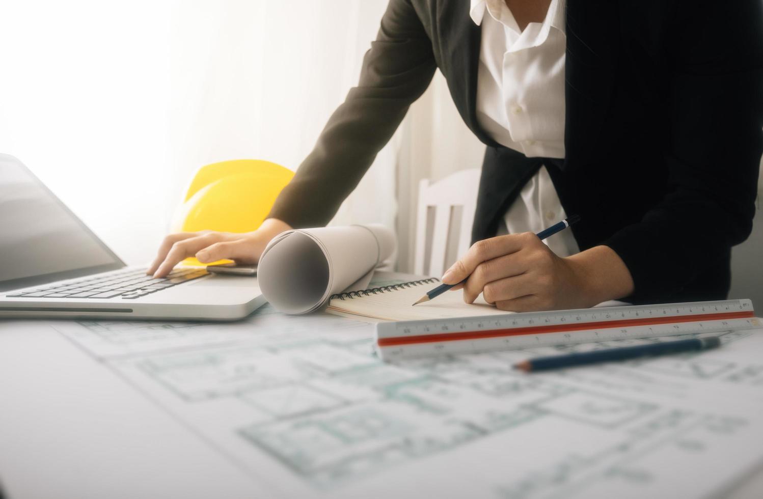 bedrijf hand- werken en laptop met Aan Aan bouwkundig project Bij bouw plaats Bij kantoor bureau in kantoor foto