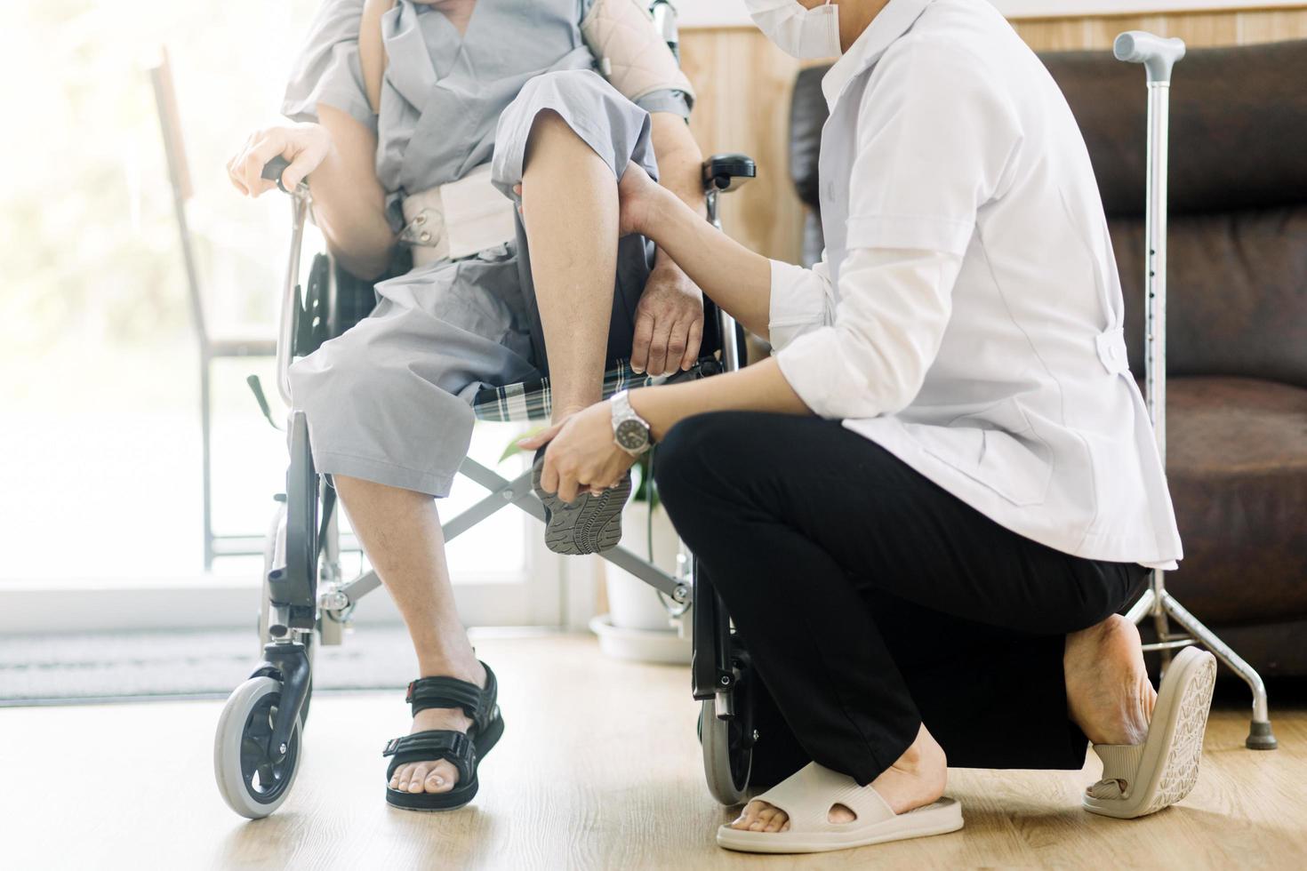 fysiotherapeut helpen senior vrouw met wandelaar Bij remediërend gymnastiek foto